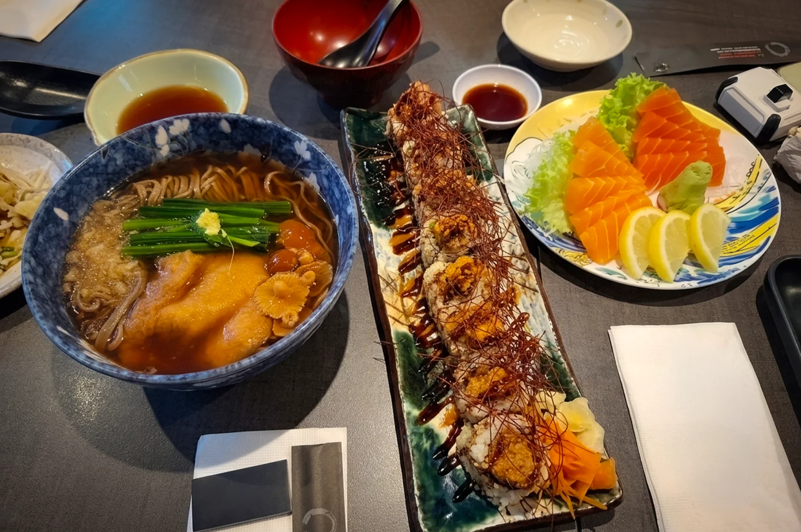Japanese vegetarian meal at Herbivore Singapore featuring sushi rolls, salmon-style sashimi, and a bowl of noodles with vegetables and broth