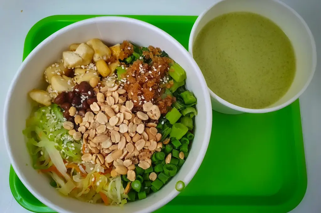 Vegetarian rice bowl with peanuts, tofu, greens, and sesame served with soup at Living Wholesome Singapore