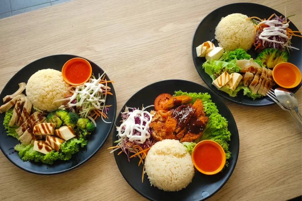 Vegetarian rice plates with mock meat, vegetables, and chili sauce at Red Apple Veggie Cafe Singapore